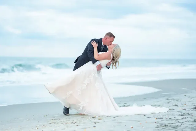 Groom dipping the bride for a kiss on the beach at Patrick and Chelsea's wedding in Myrtle Beach