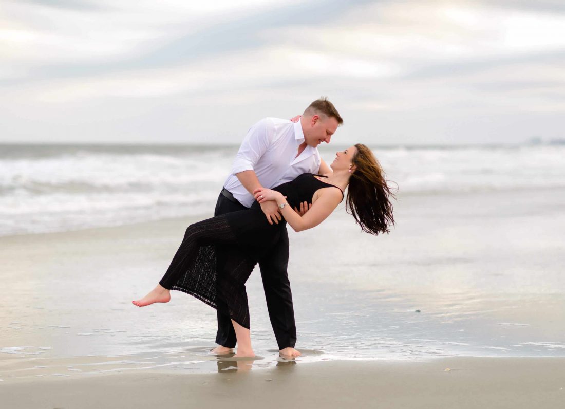 Dipping girl back in front of the ocean