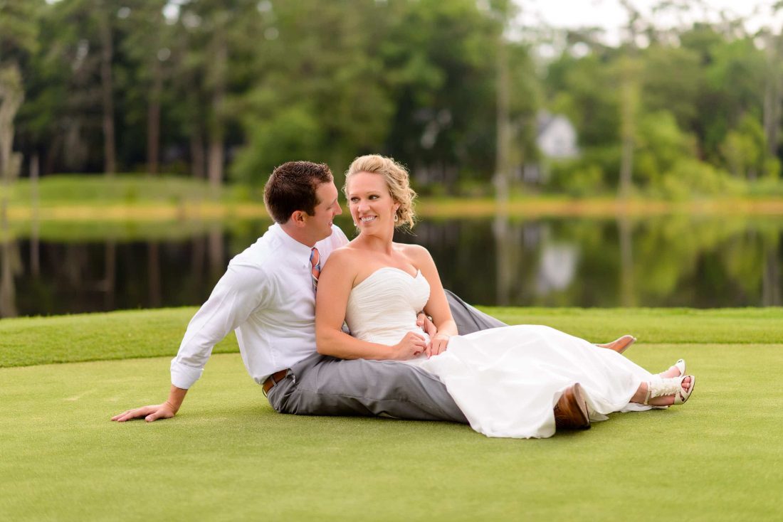 Bride and groom sitting together of golf course greens