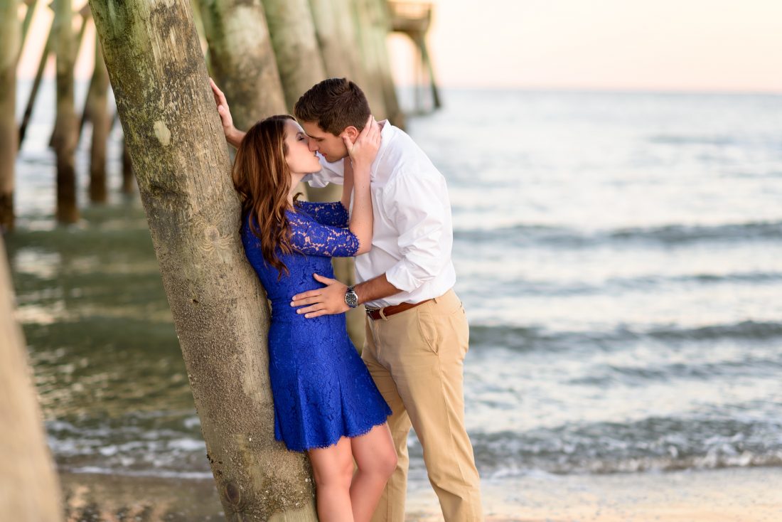 Couple about to kiss leaning against the pier at state park