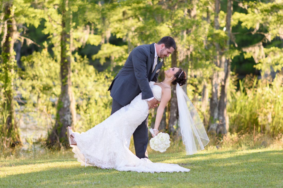 Groom dipping bride in front of the sunset - Upper Mill Plantation