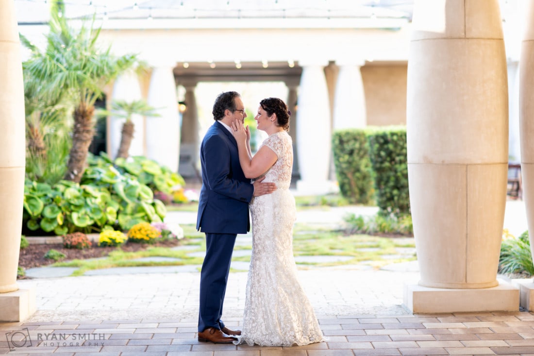 Bride touching grooms face under the columns - 21 Main Events