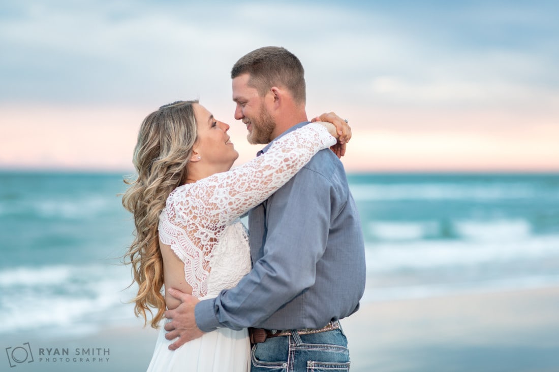 Closeup portrait of man and woman looking into each other's eyes. - Huntington Beach State Park