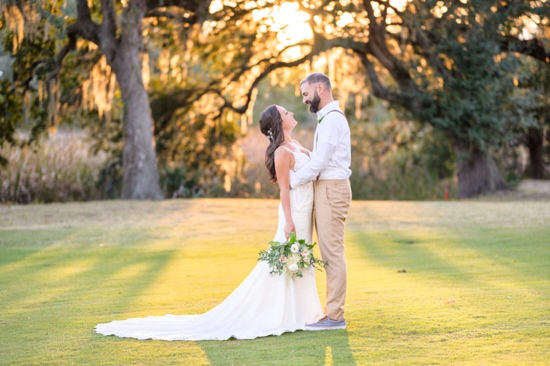 Bride and groom looking at each other framed by a old oak in the background - Pawleys Plantation