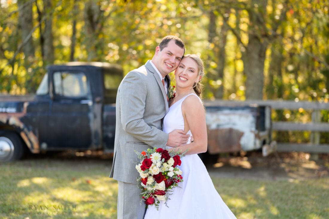 Portraits with the bride and groom in front of the old truck - The Blessed Barn