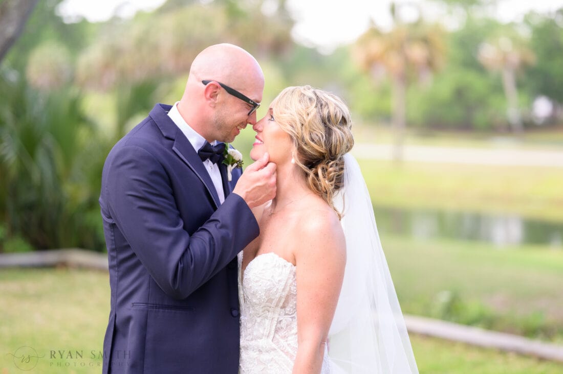 Groom pulling bride in for a kiss touching nose - The Village House at Litchfield