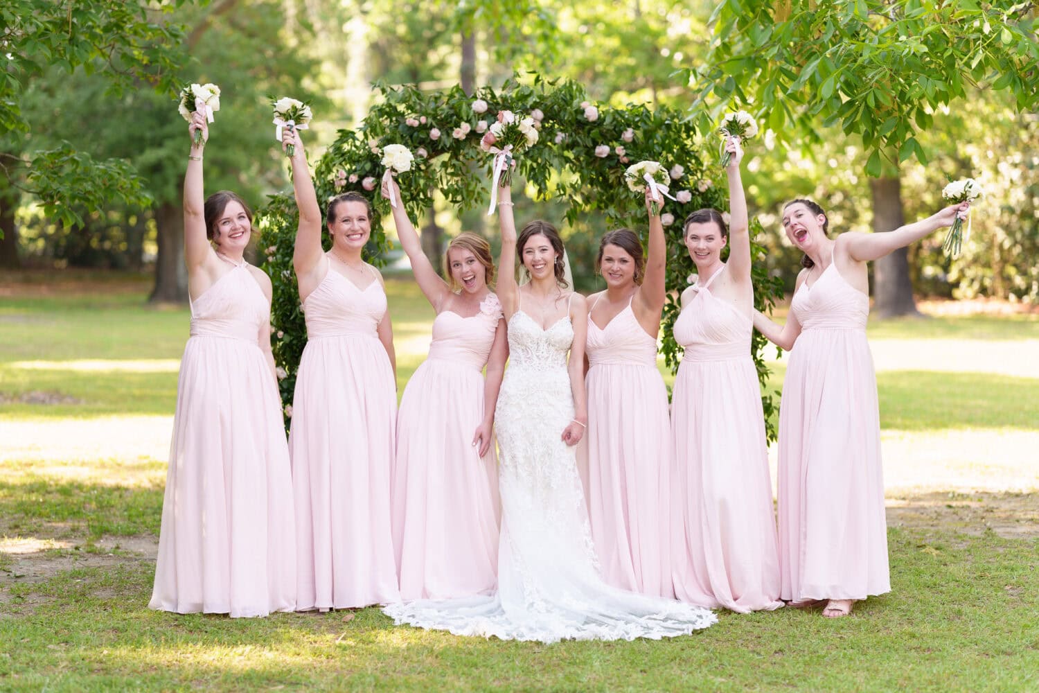 Bridesmaids holding flowers in the air - Tanglewood Plantation