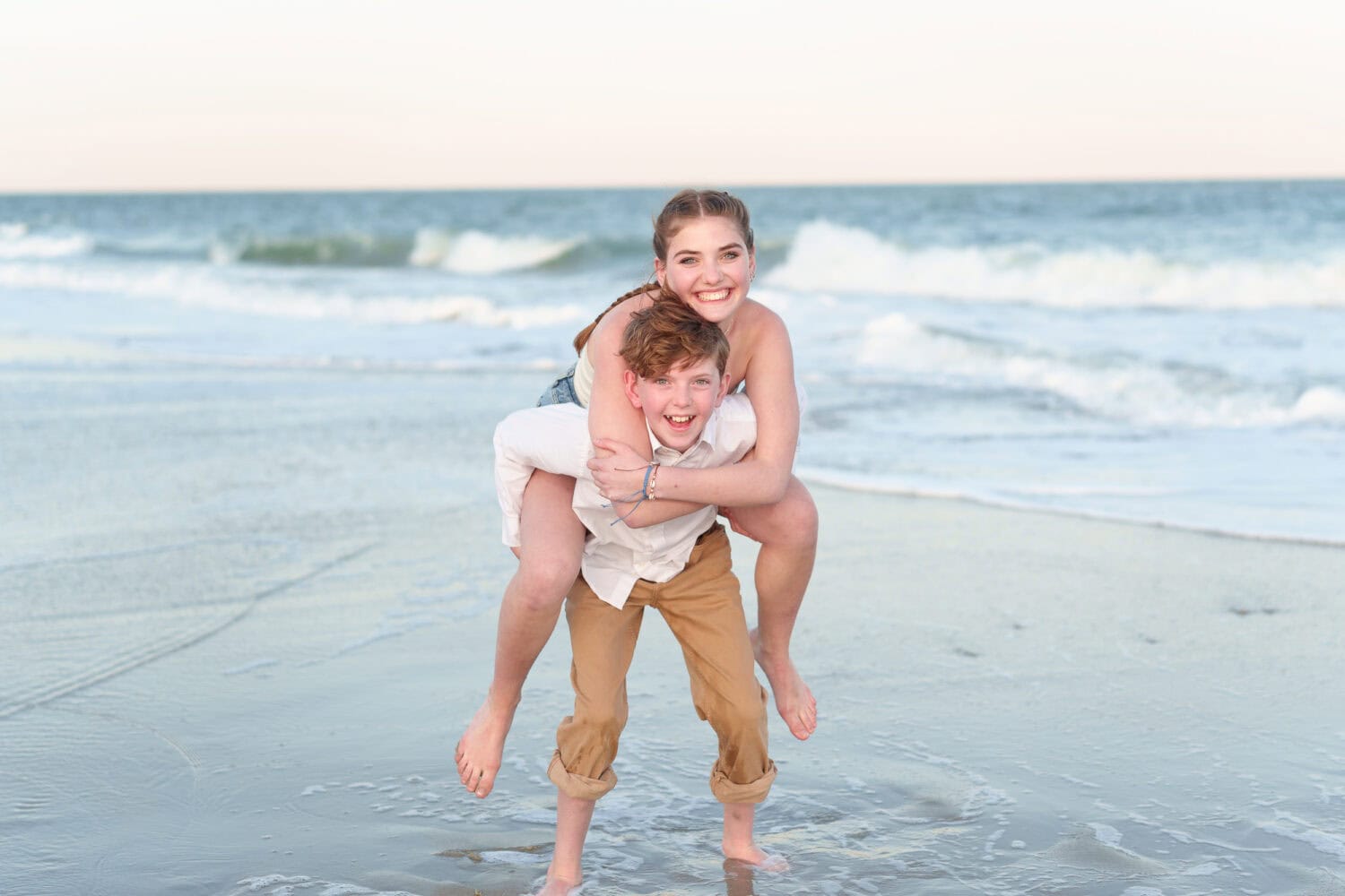 Brother giving his big sister a piggyback ride - Huntington Beach State Park