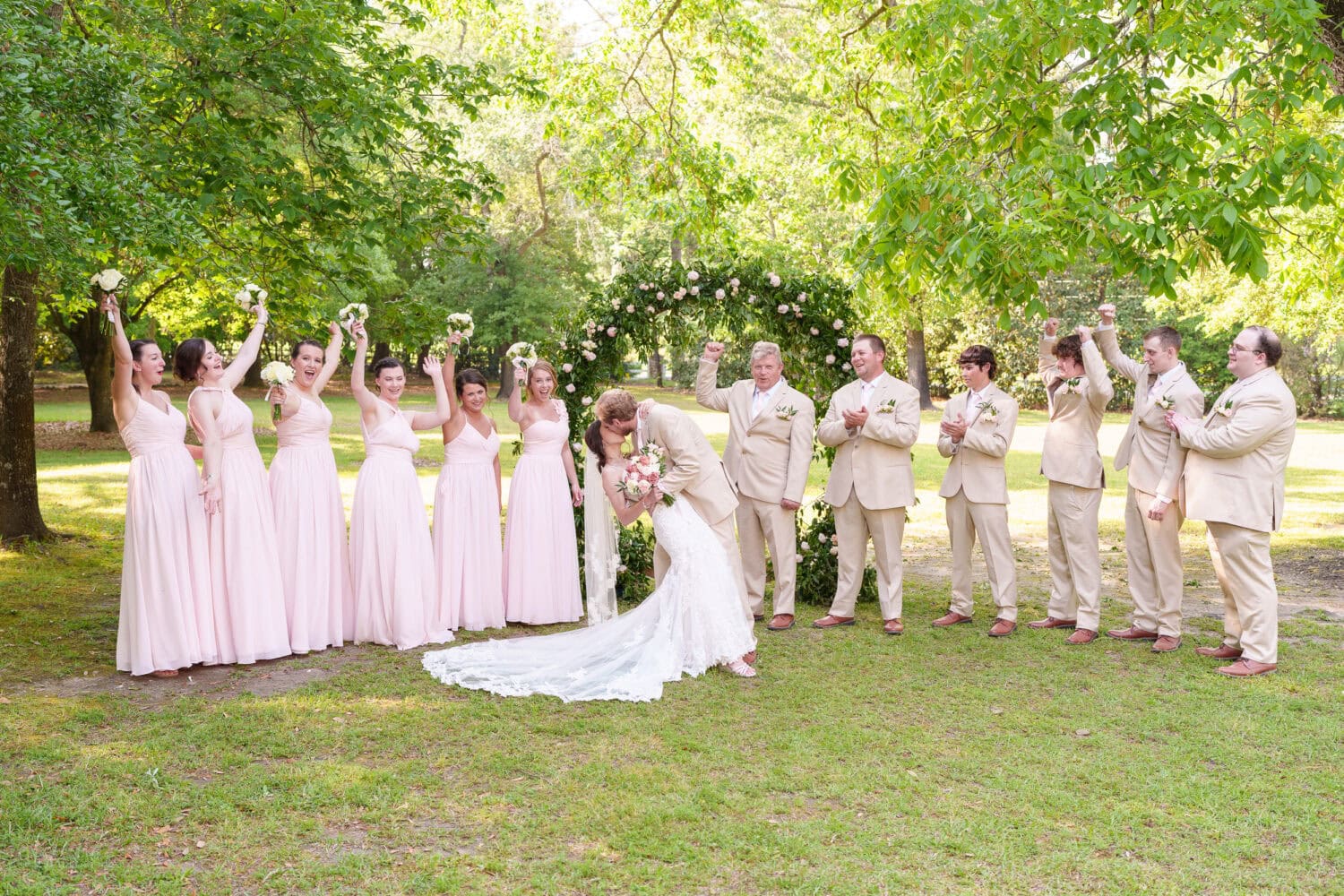 Dip back for a kiss with wedding party cheering - Tanglewood Plantation