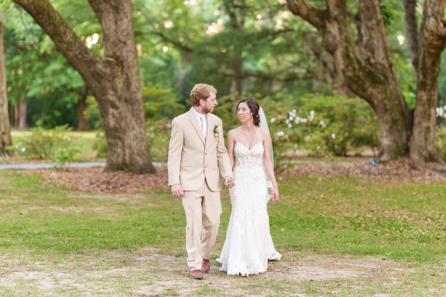 Holding hands walking under the trees - Tanglewood Plantation