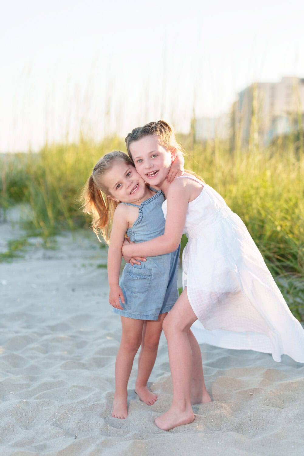 Big sister giving little sister a hug by the dunes - North Myrtle Beach