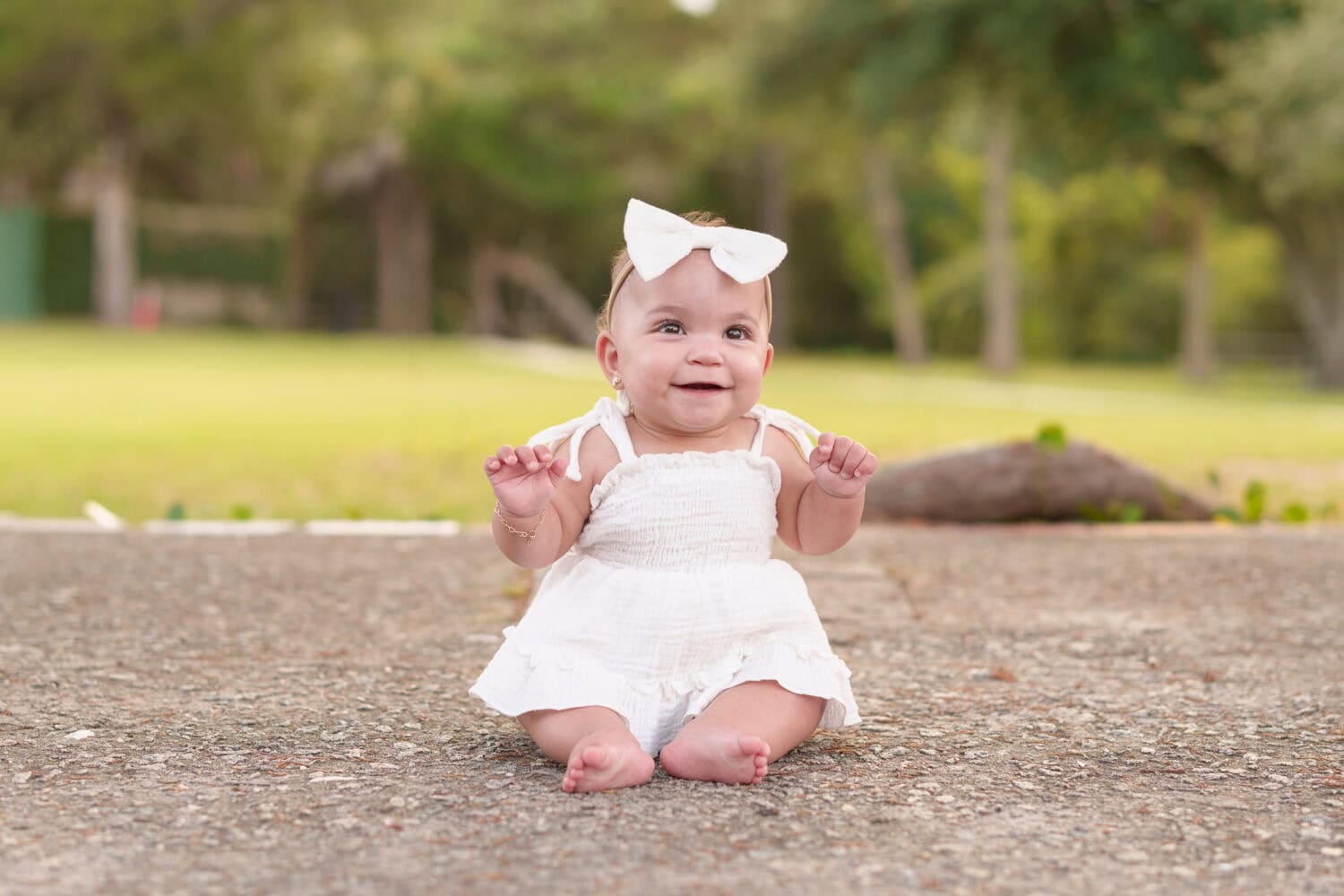 Happy baby girl sitting under the trees - Huntington Beach State Park