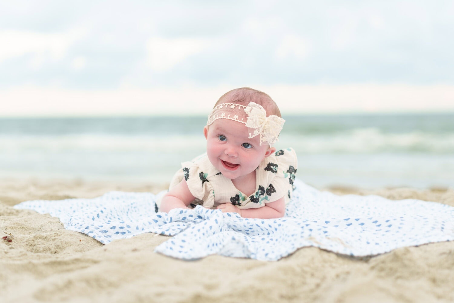 Happy baby laying on a blanket in front of the ocean - Pawleys Island