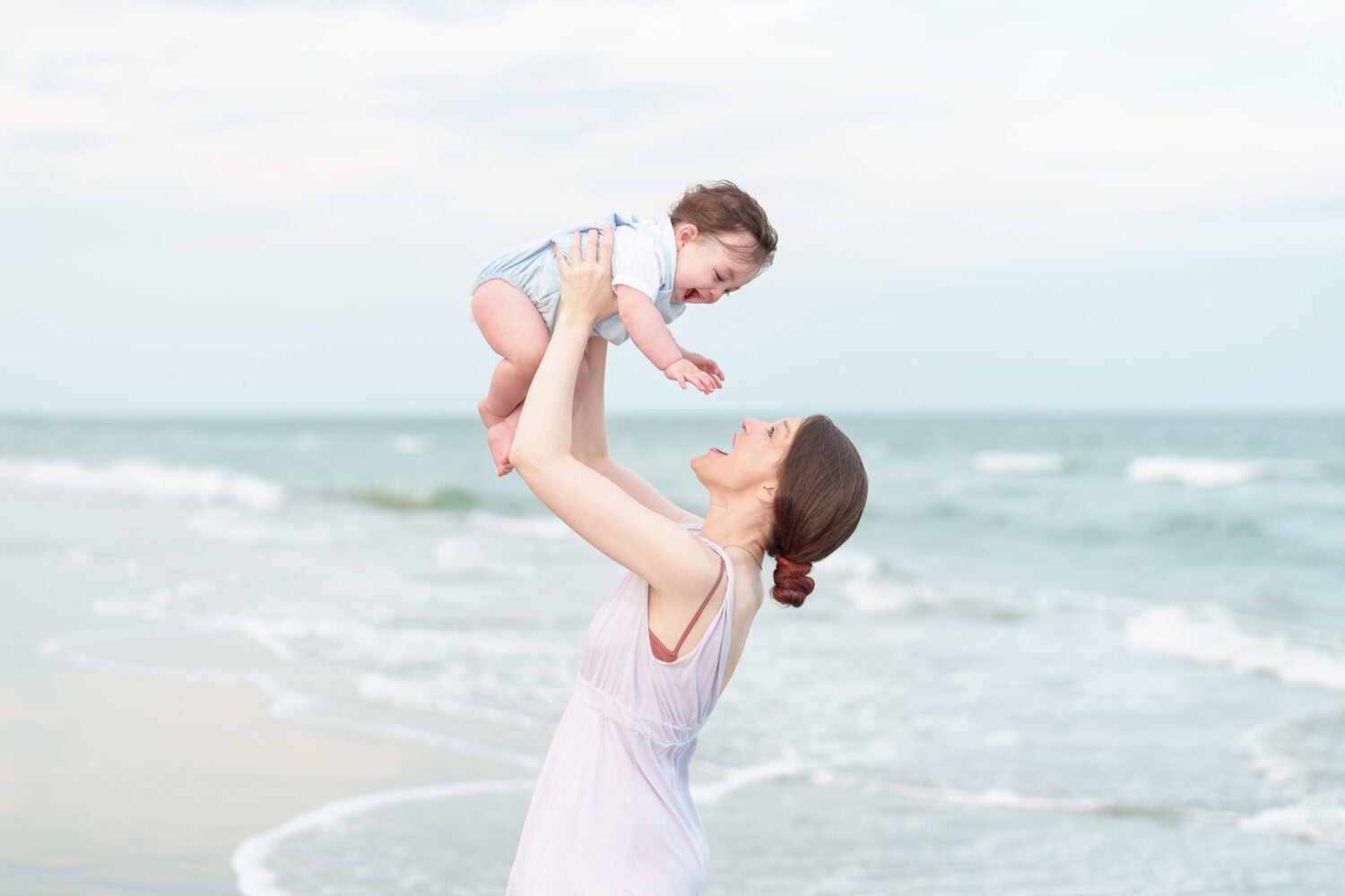 Mom lifting baby boy in the air in front of the ocean - Huntington Beach State Park - Pawleys Island