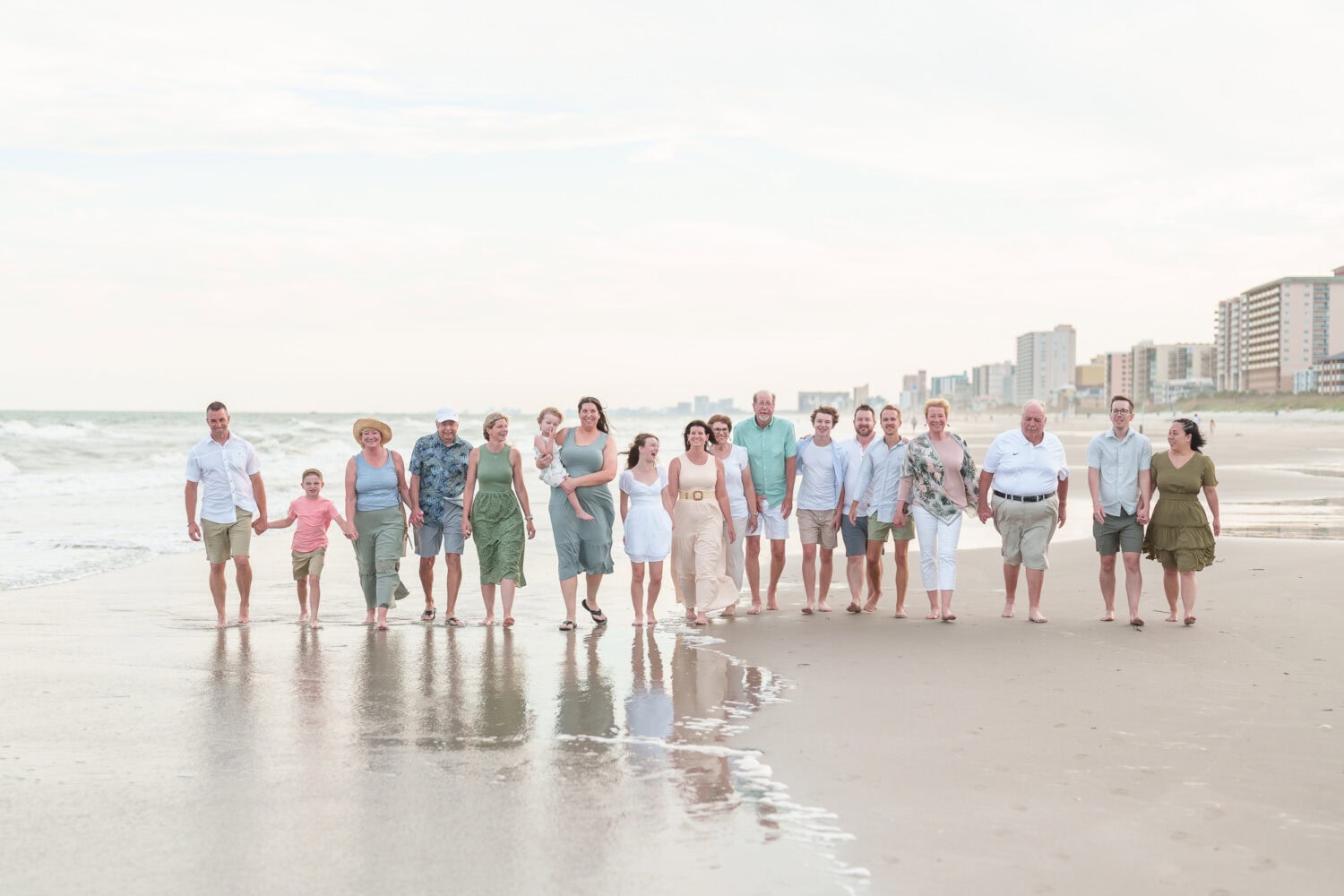 Big family walking down the beach with hotels in the background - Myrtle Beach