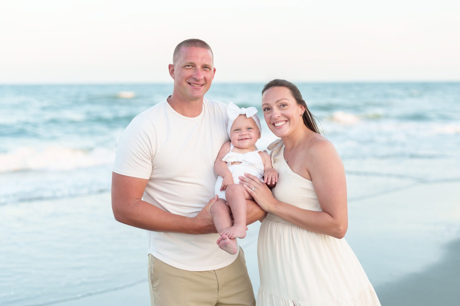 Mom and dad holding baby girl by the ocean - Myrtle Beach