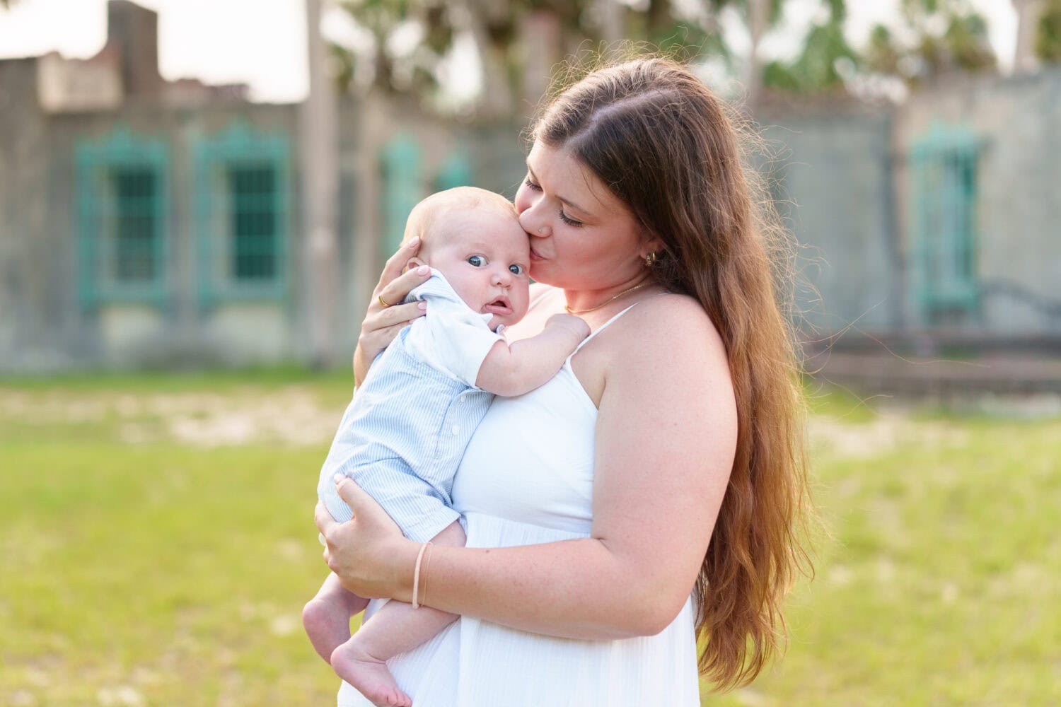 Mom holding baby daughter behind the castle - Huntington Beach State Park