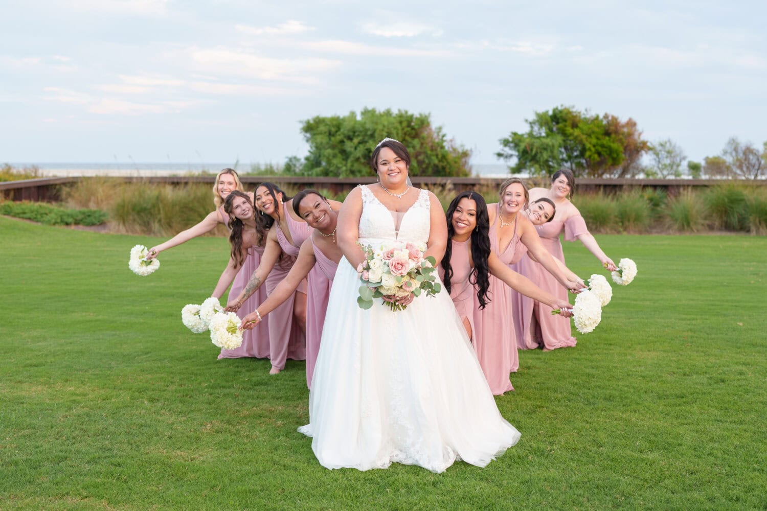 Bridesmaids peeking out from behind the bride - Dunes Golf & Beach Club