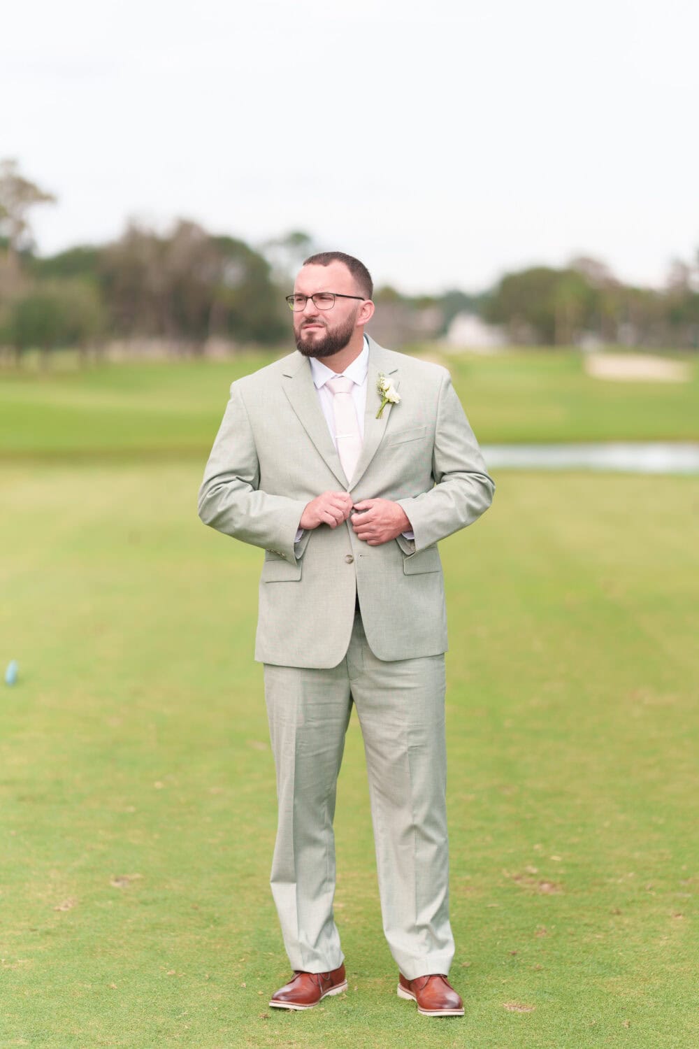 Groom buttoning up his jacket - Dunes Golf & Beach Club