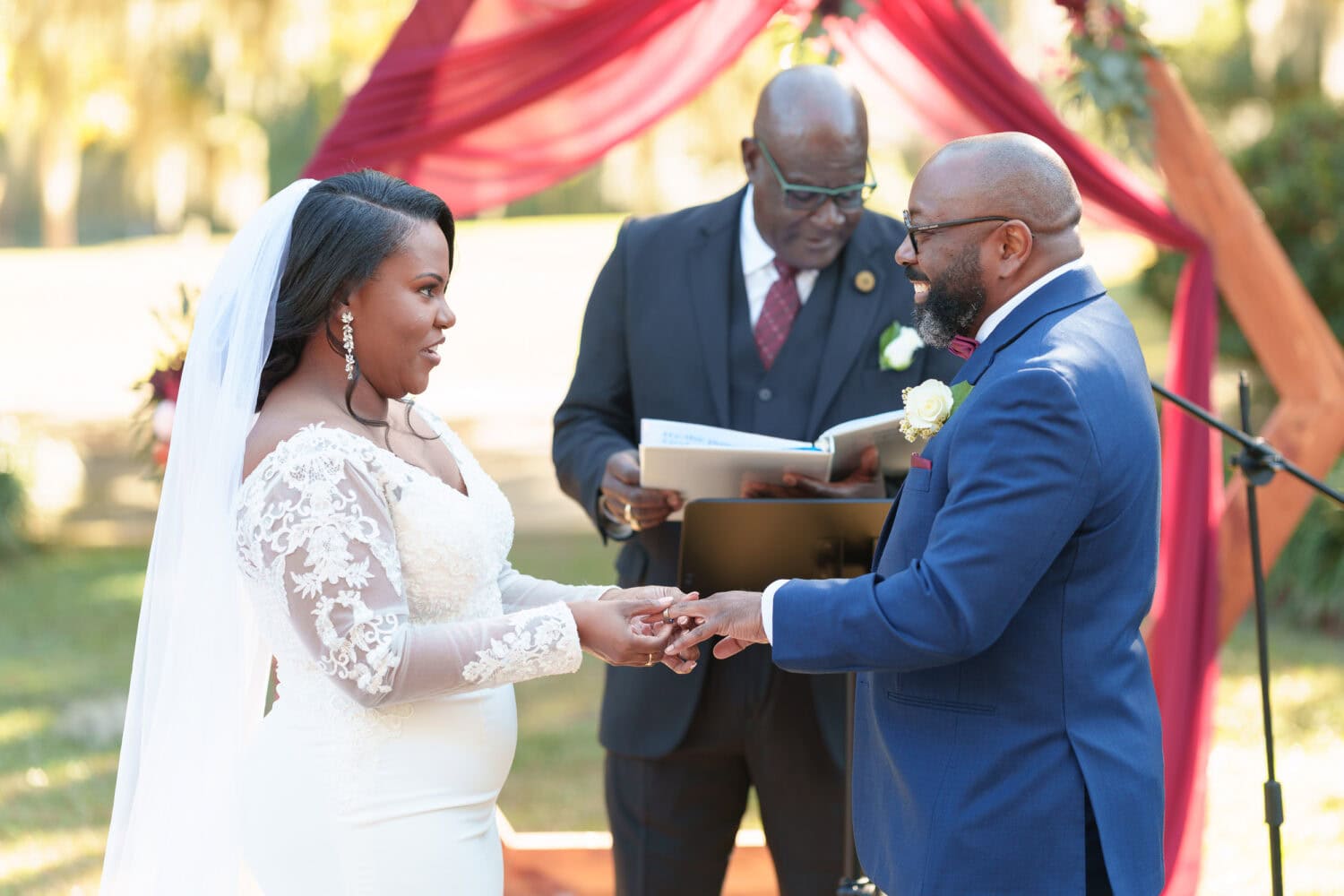 Bride putting ring on the groom - Wedgefield Country Club