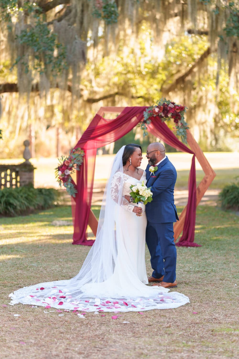 Portraits of the bride and groom in front of the ceremony flowers - Wedgefield Country Club