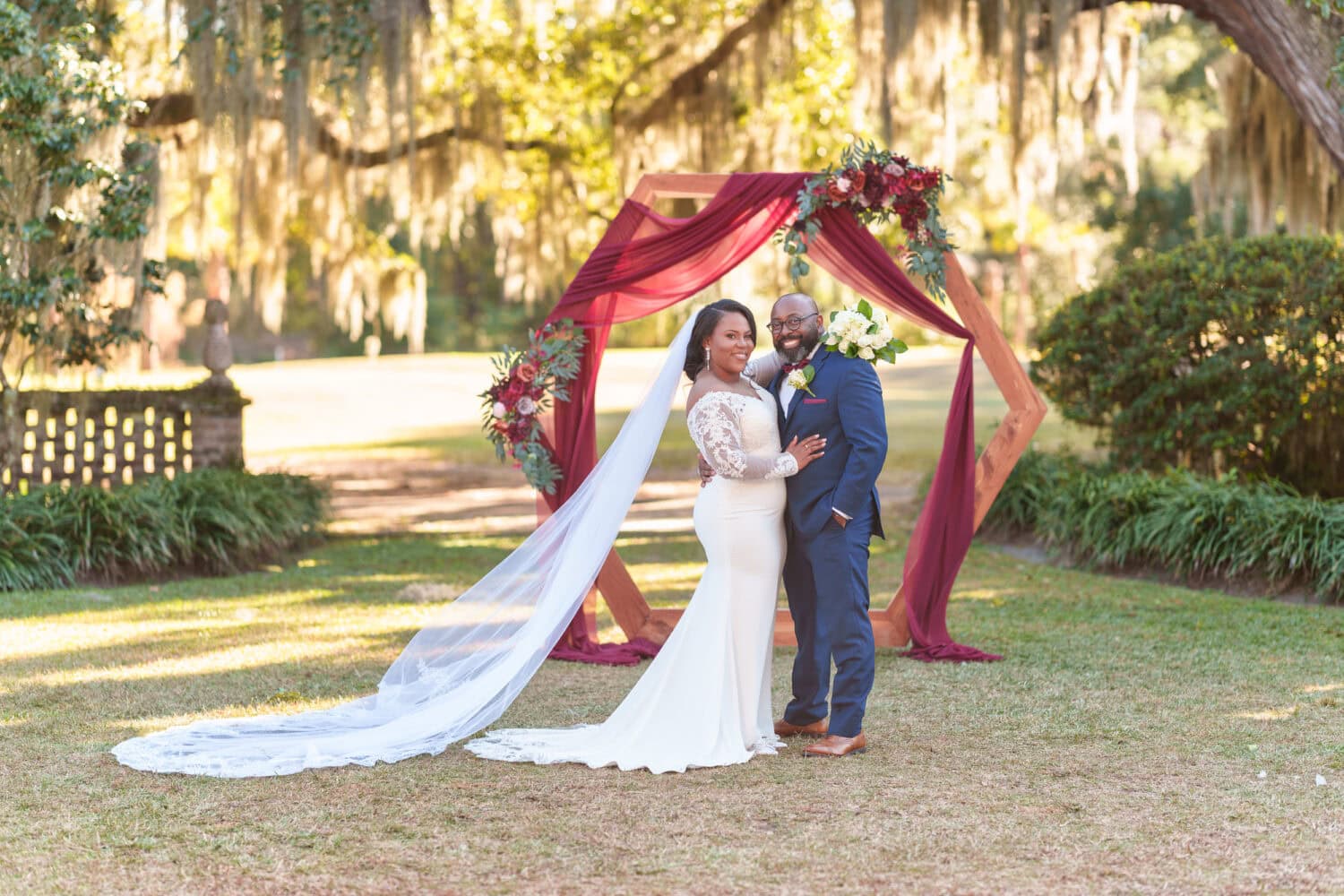 Portraits of the bride and groom in front of the ceremony flowers - Wedgefield Country Club