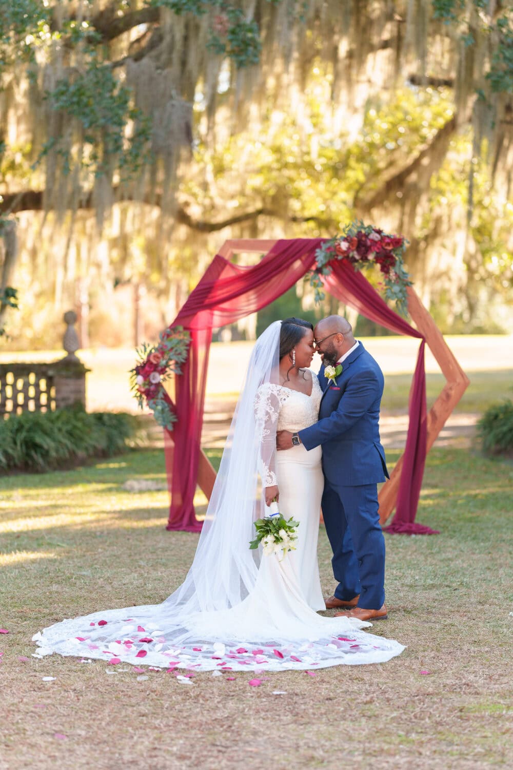 Portraits of the bride and groom in front of the ceremony flowers - Wedgefield Country Club