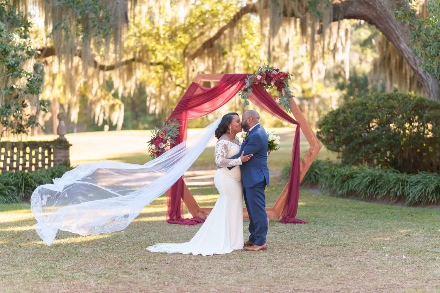 Portraits of the bride and groom in front of the ceremony flowers - Wedgefield Country Club