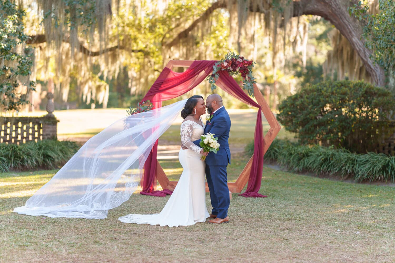 Portraits of the bride and groom in front of the ceremony flowers - Wedgefield Country Club