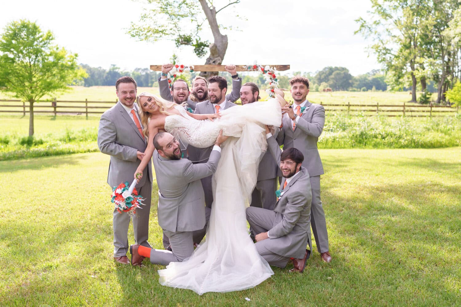 Groomsmen lifting bride into the air - Wildhorse at Parker Farms