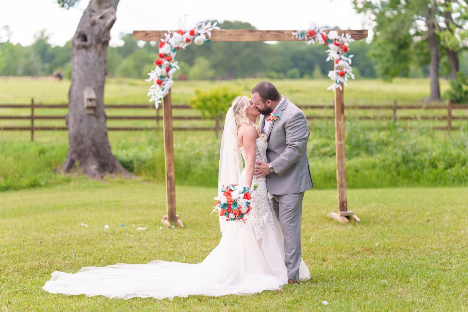 Kiss under the wedding arch - Wildhorse at Parker Farms