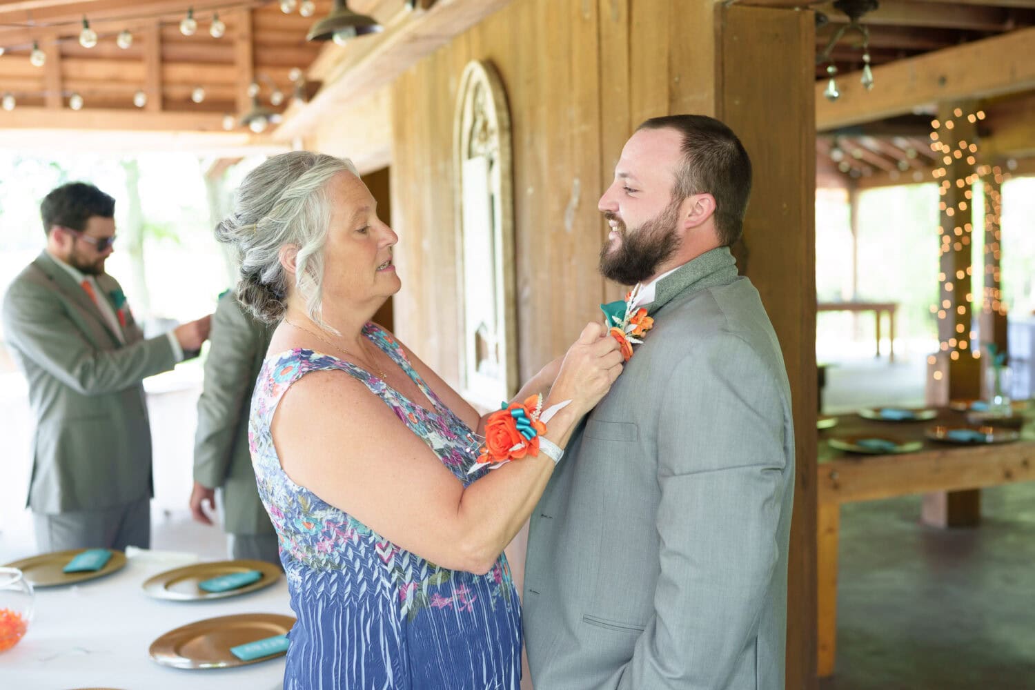 Mom helping groom with boutonniere  - Wildhorse at Parker Farms